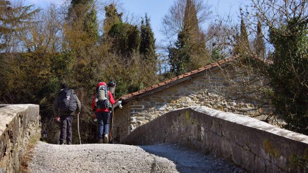 Two pilgrims cross the Zubiri Bridge